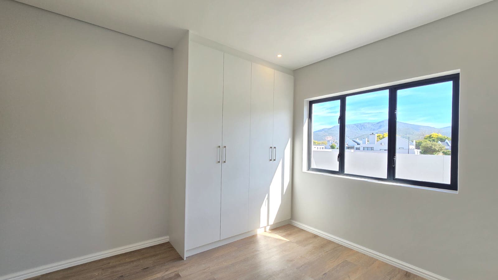 Bedroom with built-in cupboards and a mountain outlook