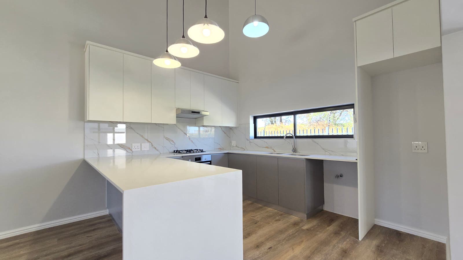 Kitchen with pendant lighting and stone-look tops